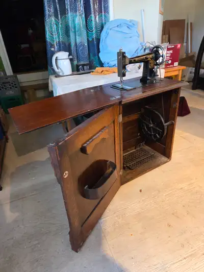 Antique sewing machine in table, View more