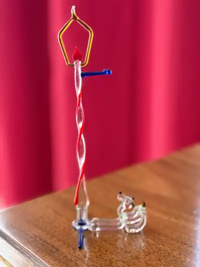 Add a touch of whimsy to your collection with this delightful glass figurine. It features a charming...