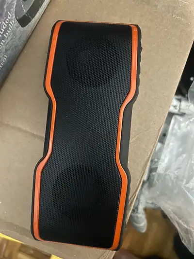 Listen to your favourite tunes on the go with this portable black and orange bluetooth speaker. It's...