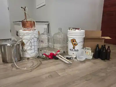 Comprehensive homebrewing equipment kit. Kit has two Ale Pail 5-gallon buckets, two large carboys on...