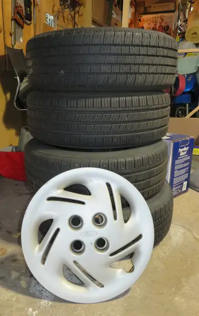 Selling a complete set of four 14-inch winter tires with rims and rim covers, plus a tire rack inclu...
