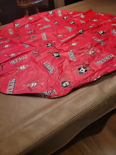 Poker motif table cloth. Plastic on top with fabric underside. Measures 57" round.