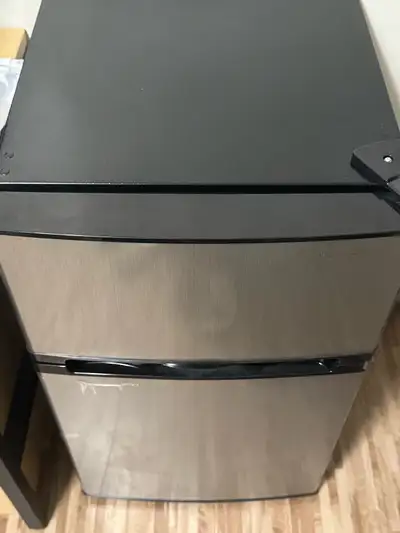 Spacious Insignia mini fridge with separate freezer compartment. Has a cool stainless steel look. In...