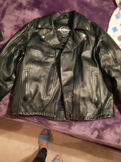 Brand new black leather motorcycle jacket (Medium) with multiple zippered pockets. Never been worn!...