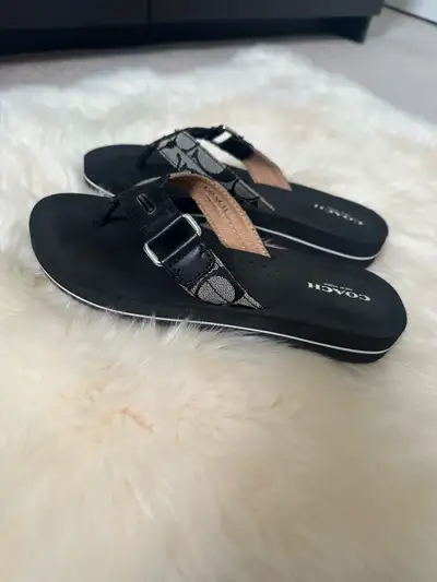 Coach sandals for women. Style: flip flops. Signature logo. Leather trim. Soft foam setting. Signatu...