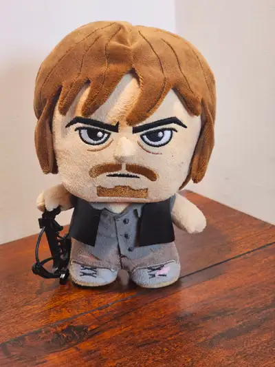 Walking Dead plush figure featuring a character with brown hair, holding a crossbow. The figure is d...