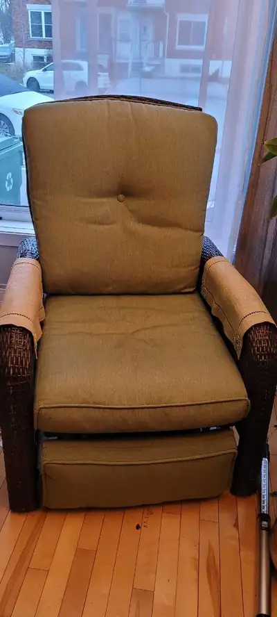 This used wicker patio chair features a pull-out foot rest and comfy green cushions, perfect for rel...