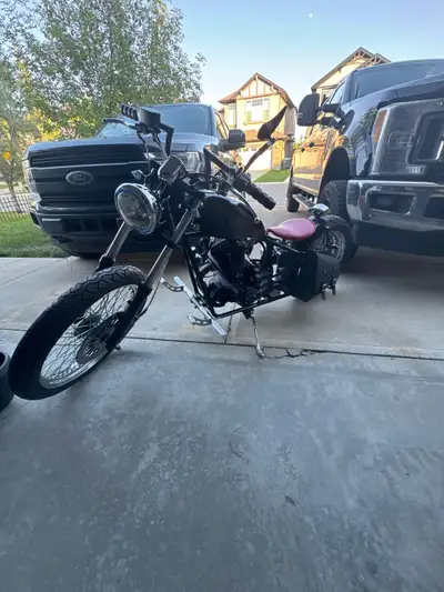 Check out this custom bobber motorcycle! It has a sleek black finish, a unique red seat, and has 242...