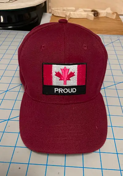 Red baseball style cap with “Canada Proud” embroidered patch on front, curved brim, new condition, u...