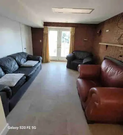 This bright and spacious walkout basement apartment features a large living area with a cozy brick f...