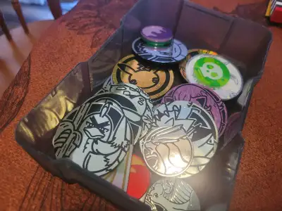 I have a small box filled with various Pokemon coins, perfect for collectors or kids who love the ga...