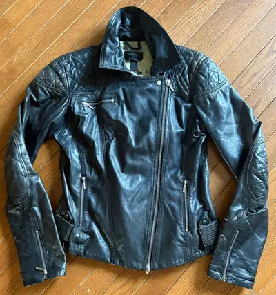 This Danier black leather jacket, size small, features a stylish asymmetrical zipper and quilted sho...