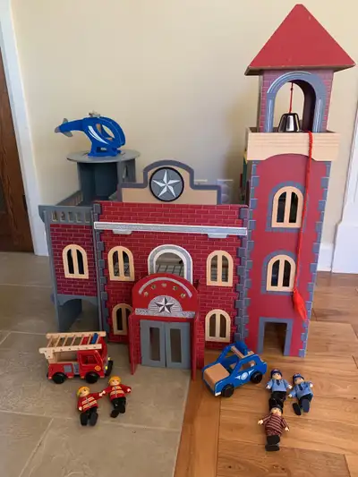 Jouet en bois comprenant caserne de pompiers avec deux garages dont les portes s’ouvrent avec un sys...