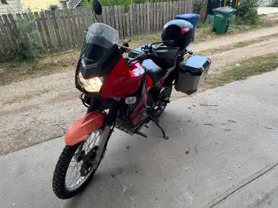 Versatile Kawasaki KLR 650 dual-sport motorcycle in red and black with 19000km. It is equipped with...