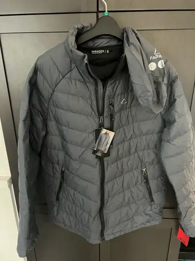 Paradox packable feather down men’s medium jacket in grey. 3 zippered pockets in front plus 2 pocket...