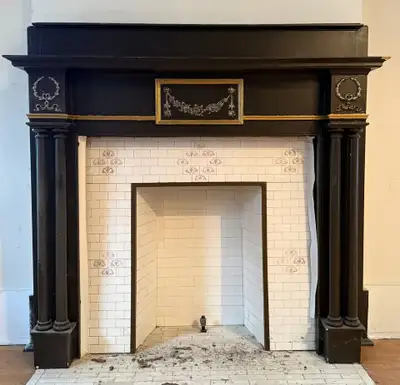 Beautiful vintage wooden fireplace mantle with classic columns and decorative detailing, removed fro...