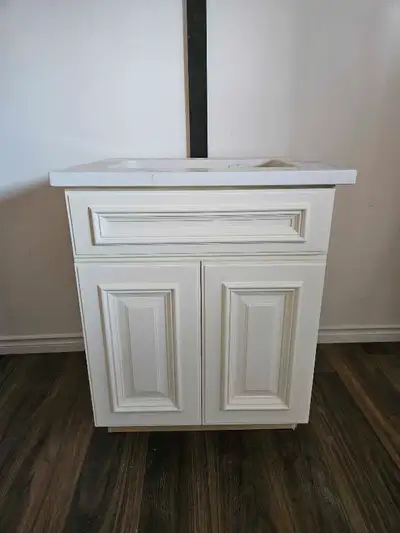Selling a standard 24" bathroom vanity with a faux marble top. It has a cabinet with doors for stora...