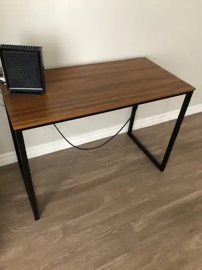 This is a stylish desk with a sleek, modern design, perfect for a home office or study space. It fea...