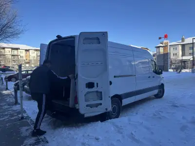 Professional moving company. Movers in uniform loading furniture and boxes into a truck. Private del...