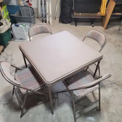 This pre-owned folding table and four-chair set features a durable metal frame with a vinyl tabletop...