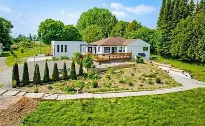 A stunning 3+1 Bedroom Bungalow sits on 1.49 acres of manicured land, featuring a serene river in th...