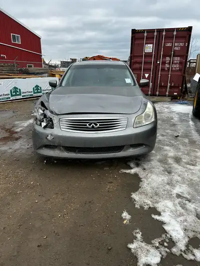 Damaged Infiniti G37xS sedan, grey color. Front left side has crumpled fender and broken headlight....