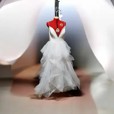 This elegant pre-loved wedding dress features a sophisticated V-neck bodice and a stunning, layered...