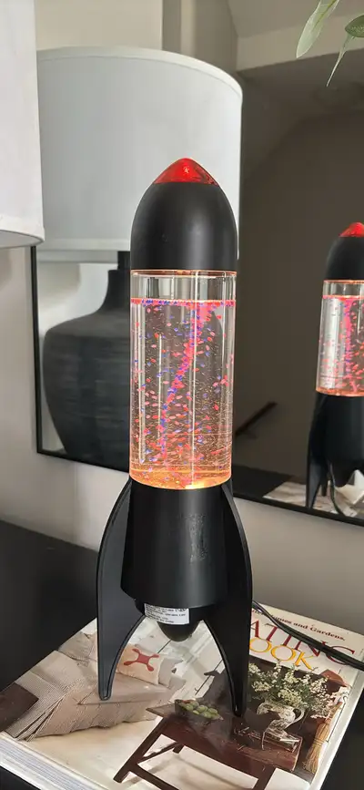 Add a blast of retro charm to your space with this rocket-shaped glitter motion lamp, which is in go...