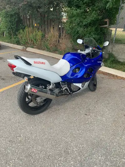 This pre-owned Suzuk katana is a powerful sportbike featuring a bold blue and white color scheme and...