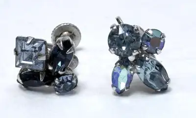 Vintage signed Sherman earrings with brilliant blue rhinestones in a silver-tone setting. Screw-back...