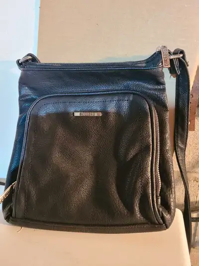 This Roots 73 black cross body bag is perfect for carrying your essentials in style! This stylish an...