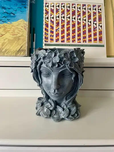 Decorative resin planter featuring a serene woodland maiden surrounded by flowing vines, ivy, and bl...