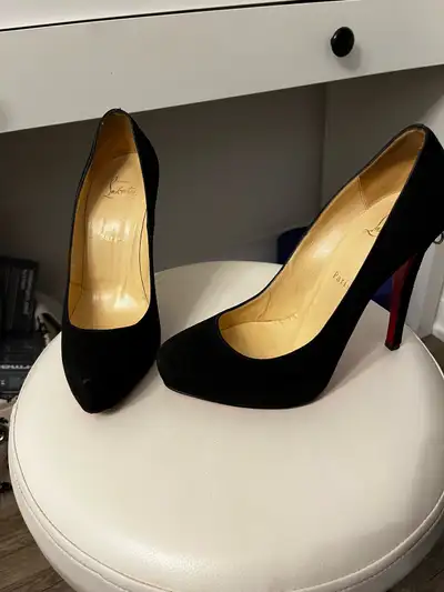 Gently used black suede Christian Louboutin heels. The shoes have a red heel and are in good conditi...