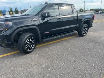 This pre-owned GMC Sierra 1500 AT4 is a powerhouse on wheels, featuring a bold black exterior and a...