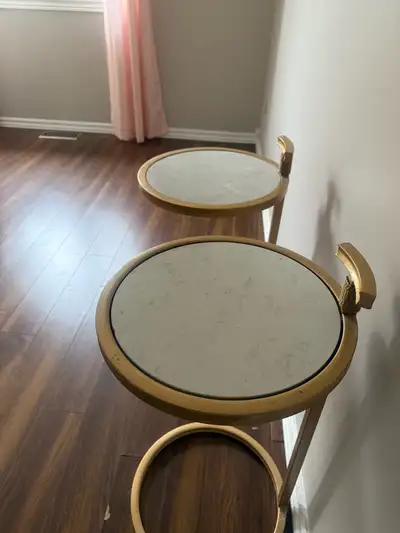 I'm selling a set of two used night stands with gold bases and faux marble tops. These night stands...