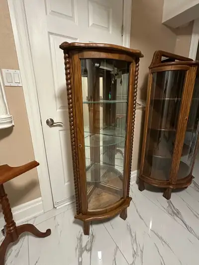 Selling a lovely vintage corner curio display cabinet! It features a wood frame with glass panels, p...