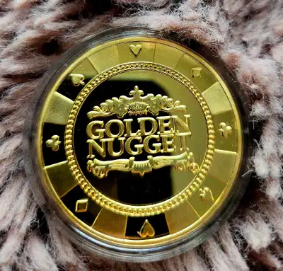 This pre-owned Golden Nugget casino chip features a striking gold-tone finish with detailed card sui...