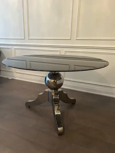 Selling a stylish dining table with a sleek black glass round top. The base is a unique silver colou...