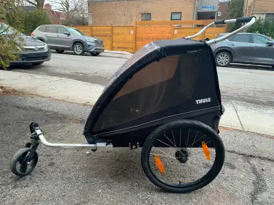 Thule double chariot stroller for walking, running or biking. Two years old, with a minor slit in th...