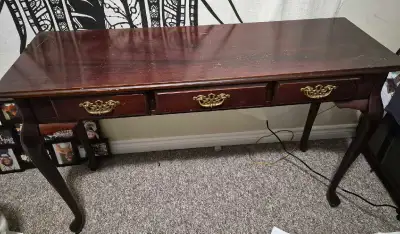This elegant Queen Anne style hall table features three spacious drawers with classic brass-toned ha...