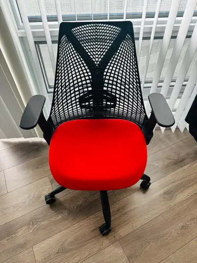Comfortable office chair. Black mesh back and frame. Red fabric seat. Five-star base with casters. E...