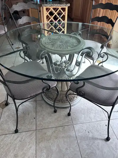 Classic 56 inch wrought iron glass top dining table. 6 chairs. Apholstered seats. Excellent conditio...