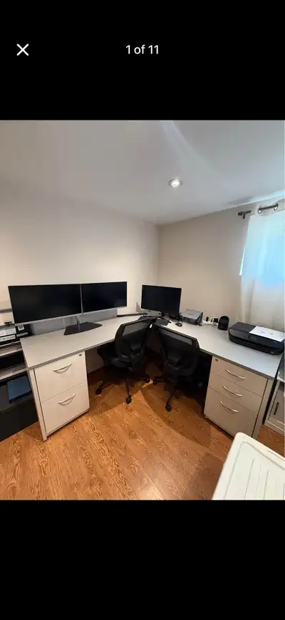 L-shaped office desk with two chairs and Two Monitors, View more