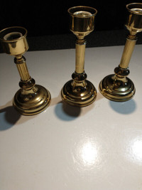 Set of 3 brass candlesticks.