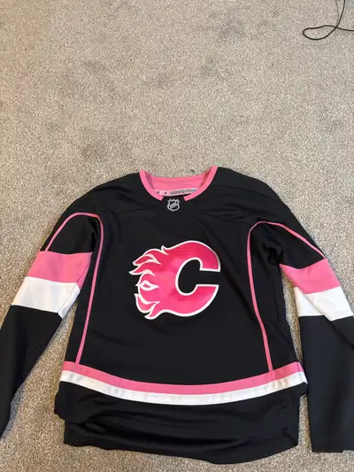 Get ready to show your team spirit with this NHL Calgary Flames jersey, perfect for any young hockey...