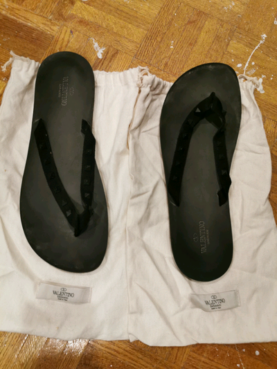 Valentino flip flop sandals. These are black with the Valentino trademark accents. They were lightly...
