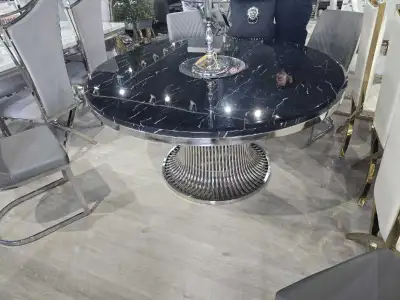 Premium black marble top dining table jiska round design modern aur classy look deta hai. Strong met...