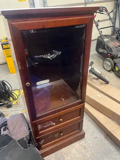 This is a used curio cabinet with a glass door and two drawers, perfect for displaying your collecti...