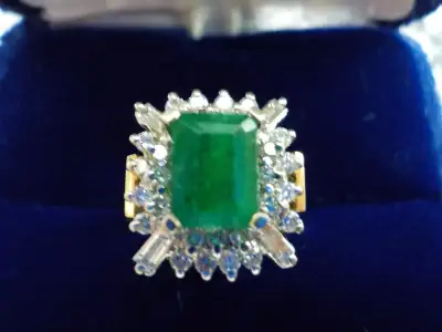 A beautifully centered, high quality 2 Carats "Deep Green to Bluish-Green" Emerald, adorned with dia...