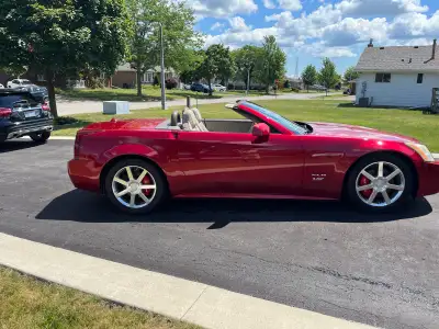 Drive in style with this stunning red Cadillac XLR, a luxury hardtop convertible that combines elega...